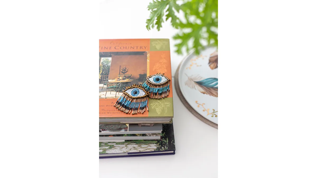 Petits bijoux à motif d'œil bleu disposés sur des livres