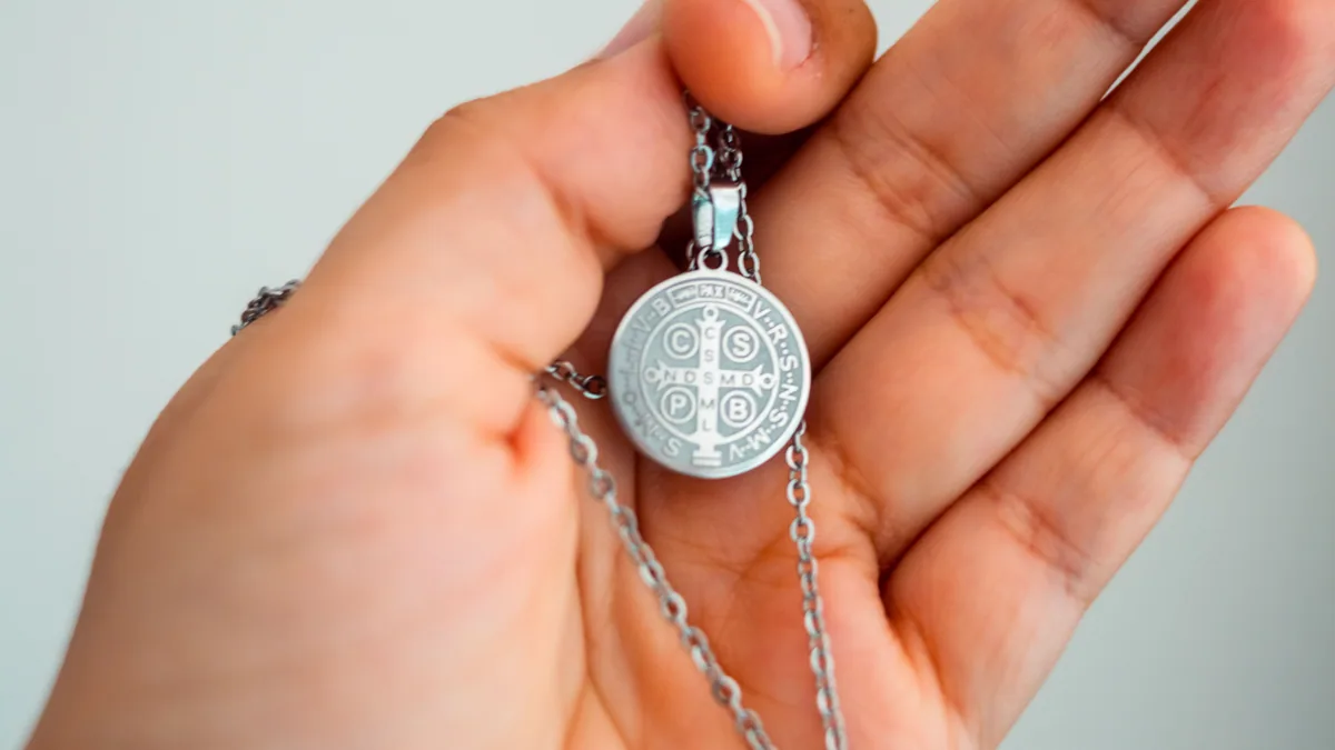 Médaille de saint Benoît présentée dans une main